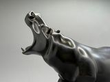 une statue représentant un hippopotame la gueule ouverte, la gueule grande ouverte