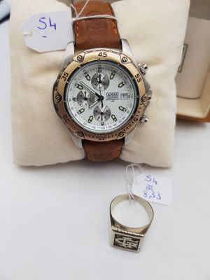 la montre est posée sur un oreiller, à côté d'une bague