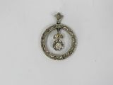 a close up of a silver pendant with a diamond in the center