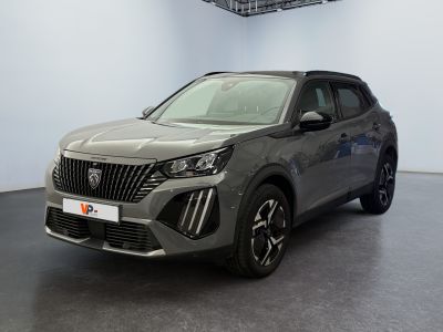 Le SUV gris est garé dans une grande pièce au sol noir.