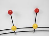 three red, yellow and black pins on a white surface