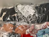 a lot of clothes in a plastic bag on a table