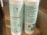 deux flacons d'après-shampoing posés sur une boîte en carton