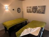 two beds in a room with a painting on the wall