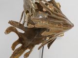 sculpture of a frog on a wire on a white surface