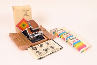 un appareil photo Polaroid et quelques livres posés sur une table