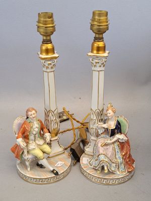paire de figurines en porcelaine représentant un homme et une femme assis sur une chaise