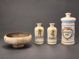 three vases and a bowl sitting on a table next to each other