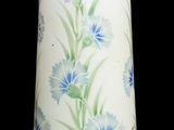 un vase blanc orné de fleurs bleues sur fond noir