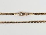 a close up of a gold chain on a white surface