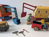 four different types of toy vehicles and tools on a white surface