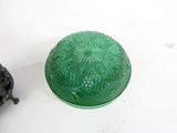 a green glass container with a turtle on it