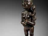une statue en bronze d'une femme tenant un enfant dans ses bras
