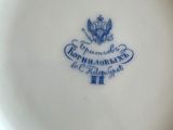 a close up of a white plate with a blue emblem on it