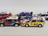 several toy cars are lined up in a row on a white surface