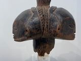 a wooden elephant head on top of a glass stand