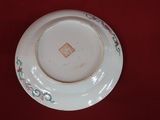 a white plate with flowers on it on a red surface