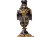 a blue and gold vase sitting on a stand