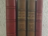 several old books are lined up on a white surface