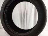 a close up of a tire on a white surface with a curtain in the background