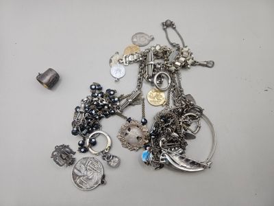 a lot of silver jewelry on a white table