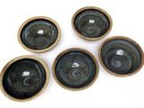 six black and brown bowls sitting on top of a white surface