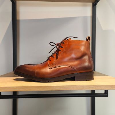 des bottes en cuir posées sur une étagère dans un magasin de chaussures