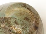 a green and brown bowl sitting on a white surface