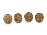 quatre pièces d'or sont disposées en ligne sur une surface blanche