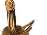 a close up of a gold sword with a red stone on it