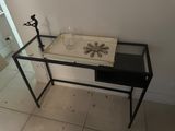 a glass table with a glass top and a metal frame