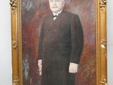 portrait d'un homme en costume-cravate dans un cadre doré