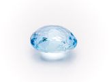 a close up of a blue diamond on a white surface
