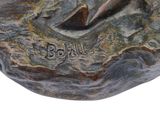 sculpture of a man on a rock with a surfboard in his hand