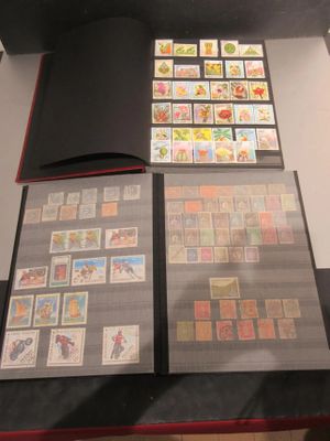beaucoup de timbres posés sur une table, à côté d'un livre