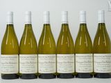 six bouteilles de vin blanc alignées sur une table