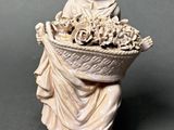 figurine of a woman holding a basket of flowers