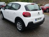 a small white car parked in a parking lot