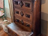 a wooden chest of drawers in the corner of a room