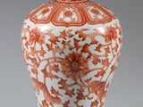 un vase orange et blanc posé sur une table