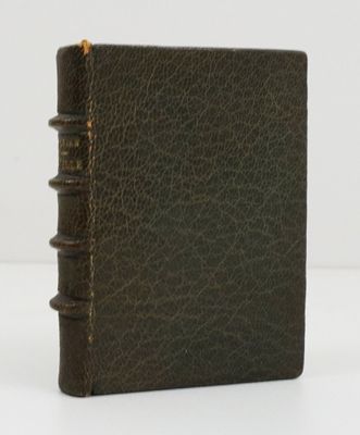 un vieux livre en cuir marron posé sur une table blanche