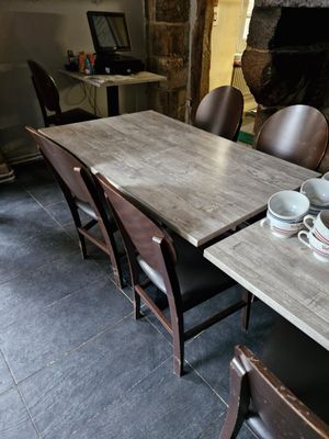 des tables et des chaises dans une pièce avec une cheminée en arrière-plan