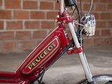 a close up of a red motorcycle parked in front of a brick wall