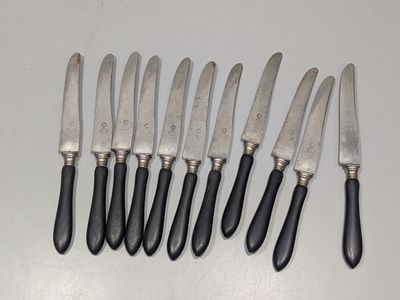 six couteaux sont alignés sur une table