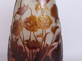 a glass vase with a design of flowers and leaves on it