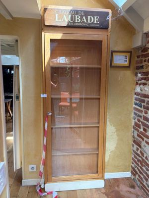 a glass door with a sign on it in the corner of a room