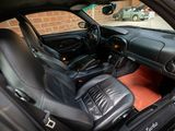 the interior of a car with black leather seats and a red carpet