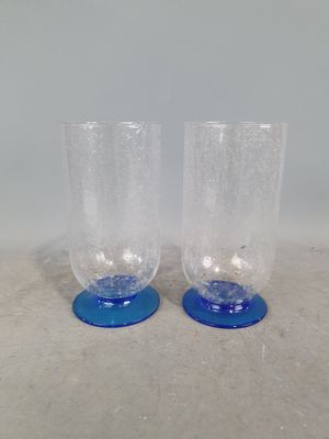une paire de verres bleus et transparents posés sur une surface blanche