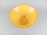 a yellow bowl sitting on top of a white table