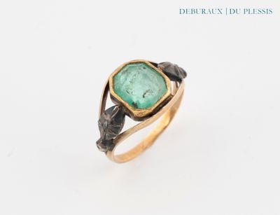 a close up of a ring with a green stone in it